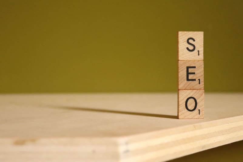 Three scrabble tiles arranged vertically spell out SEO